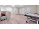 Large game room boasts wood floors and a game table with doors leading to other parts of the house at 5045 Ivory Stone Dr, Wimauma, FL 33598