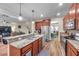 Open kitchen with wood floors features granite countertops, stainless appliances and view of the living and dining rooms at 5045 Ivory Stone Dr, Wimauma, FL 33598