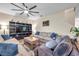 Relaxing living room space with comfortable sofas, entertainment center, hardwood floors, and modern ceiling fan at 5045 Ivory Stone Dr, Wimauma, FL 33598