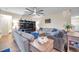 Cozy living room featuring comfortable sofas, stylish decor, and a decorative ceiling fan at 5045 Ivory Stone Dr, Wimauma, FL 33598