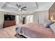 Spacious main bedroom with a ceiling fan, accent wall, and multiple doors leading to the walk in closet and bathroom at 5045 Ivory Stone Dr, Wimauma, FL 33598
