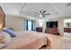 Main bedroom boasts a ceiling fan, accent wall, plush bedding, and light wood floors at 5045 Ivory Stone Dr, Wimauma, FL 33598