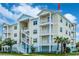 Stunning exterior of a multi-story condo featuring balconies, white railings, and lush landscaping at 7611 34Th W Ave # 303, Bradenton, FL 34209