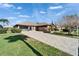 Charming one-story home featuring a paved driveway, manicured lawn, screened porch, and beautiful landscaping at 1228 Caloosa Creek Ct, Sun City Center, FL 33573