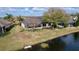 Exterior view of a home with a pond and mature landscaping at 26848 Shoregrass Dr, Wesley Chapel, FL 33544