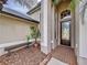 Inviting home entrance with decorative glass door, brick walkway, and a cozy bench at 26848 Shoregrass Dr, Wesley Chapel, FL 33544