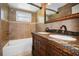 Bathroom featuring decorative vanity, soaking tub, tile walls, and window at 3087 Duane Ave, Oldsmar, FL 34677