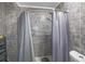 Shower area with gray tile surround, shower curtain, and updated fixtures at 3087 Duane Ave, Oldsmar, FL 34677