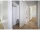 Hallway with an open closet, showing natural light and neutral tile floors leading to other rooms at 3087 Duane Ave, Oldsmar, FL 34677