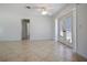 Bright living room with neutral tile, ceiling fan, and double French doors leading to the outside at 3087 Duane Ave, Oldsmar, FL 34677