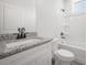 Bathroom with granite countertop, white cabinets, and combination shower and tub at 3801 Luma Dr, Holiday, FL 34691
