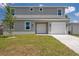 Two-story home featuring a gray exterior, a well-manicured lawn, and an attached single-car garage at 3801 Luma Dr, Holiday, FL 34691