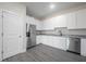 Bright kitchen with white cabinets, stainless steel appliances, granite countertops, and gray wood-look flooring at 3801 Luma Dr, Holiday, FL 34691