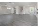 Large living room area with sleek gray laminate flooring, recessed lighting, and access to the staircase at 3801 Luma Dr, Holiday, FL 34691