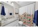 Bright bathroom with patterned shower curtain, granite vanity top, and matching mirror at 6104 S Main Ave, Tampa, FL 33611