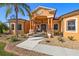 Elegant home entrance featuring a covered porch, stately columns, decorative stone accents, and meticulously maintained landscaping at 14739 Vista View Ct, Dade City, FL 33523