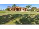 Beautiful single-story home featuring a sprawling lawn, mature trees, and a welcoming facade with a grand entrance at 14739 Vista View Ct, Dade City, FL 33523