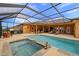 Inviting screened-in pool and spa area with ample seating and an outdoor bar at 14739 Vista View Ct, Dade City, FL 33523