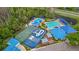 Aerial view of various community amenities including pools, basketball court, water slide, play area, and a spacious parking lot at 1746 Golden Dawn Pl, Wesley Chapel, FL 33543