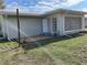 Quaint backyard view showcasing a clean, neutral-toned home exterior with a well-maintained yard and sky at 2051 High Ridge Dr, Clearwater, FL 33763