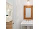 Bathroom sink with woven mirror frame and brass colored fixtures at 4614 W Tennyson Ave, Tampa, FL 33629