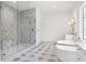 Bathroom featuring a modern glass enclosed shower, freestanding tub, double sinks, and gray and white checkered tile flooring at 4614 W Tennyson Ave, Tampa, FL 33629