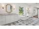 Bright bathroom with a freestanding tub, double sinks, and beautiful gray and white checkered tile flooring at 4614 W Tennyson Ave, Tampa, FL 33629