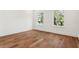 Bedroom with hardwood floors, white walls, and natural light from the two windows at 4614 W Tennyson Ave, Tampa, FL 33629