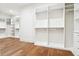 Spacious walk-in closet with wood flooring and custom white shelving and drawers at 4614 W Tennyson Ave, Tampa, FL 33629