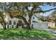 Stately two-story white home featuring a well-manicured lawn and three-car garage at 4614 W Tennyson Ave, Tampa, FL 33629