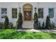 Inviting front entrance featuring a beautiful wooden door, elegant lighting, and manicured landscaping at 4614 W Tennyson Ave, Tampa, FL 33629