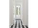 Hallway with striking black and white checkered tile flooring and white trim, leading to an outdoor balcony at 4614 W Tennyson Ave, Tampa, FL 33629