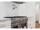Close up of a professional grade gas range, stainless steel appliances, and pot filler at 4614 W Tennyson Ave, Tampa, FL 33629