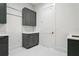 Laundry room with gray cabinets, white countertop, and white hexagon tile flooring at 4614 W Tennyson Ave, Tampa, FL 33629