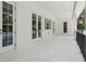 Outdoor patio featuring white walls, several glass doors, and white stone flooring at 4614 W Tennyson Ave, Tampa, FL 33629