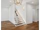 Bright staircase featuring hardwood floors, white risers, and a stylish black handrail at 4614 W Tennyson Ave, Tampa, FL 33629