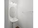 Bright powder room featuring a pedestal sink, oval mirror, and modern lighting at 4734 Chatterton Way, Riverview, FL 33578