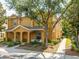 Inviting two-story home featuring a covered front porch with comfortable seating area and mature landscaping at 4734 Chatterton Way, Riverview, FL 33578