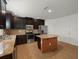Bright kitchen featuring granite countertops, stainless steel appliances, dark cabinetry, and a functional island at 4734 Chatterton Way, Riverview, FL 33578