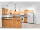 Open kitchen featuring wood cabinets, stone countertops, a breakfast bar, and essential appliances at 8150 Southern Pines Dr, Brooksville, FL 34601
