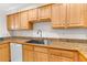 Kitchen with a stainless steel sink, wood cabinets, stone countertops, and essential white appliances at 8150 Southern Pines Dr, Brooksville, FL 34601