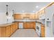 Well-lit kitchen featuring wood cabinets, stone countertops, and essential white appliances at 8150 Southern Pines Dr, Brooksville, FL 34601