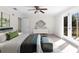Bright main bedroom with a ceiling fan, double doors to a private balcony, and a comfortable bed at 8150 Southern Pines Dr, Brooksville, FL 34601
