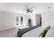 Bright main bedroom with a ceiling fan, double doors to a private balcony, and a comfortable bed at 8150 Southern Pines Dr, Brooksville, FL 34601