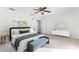 Bright main bedroom with a ceiling fan, double doors to a private balcony, and a comfortable bed at 8150 Southern Pines Dr, Brooksville, FL 34601
