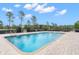 Community pool featuring clear water, a paved deck, chaise lounges, and a black wrought iron fence at 8150 Southern Pines Dr, Brooksville, FL 34601