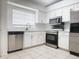 Bright kitchen with white cabinetry, stainless steel appliances, and tile flooring at 1009 Hardwood Dr, Valrico, FL 33596