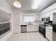 Bright kitchen featuring white cabinets, stainless steel appliances, and neutral tile flooring at 1009 Hardwood Dr, Valrico, FL 33596