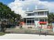 Beautiful waterfront home with multiple balconies, palm trees, and lounge area on the beach at 1522 Gulf Blvd, Indian Rocks Beach, FL 33785