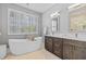 Bright bathroom featuring soaking tub, stand alone shower, double vanity, and large windows at 1881 Riveredge Dr, Tarpon Springs, FL 34689